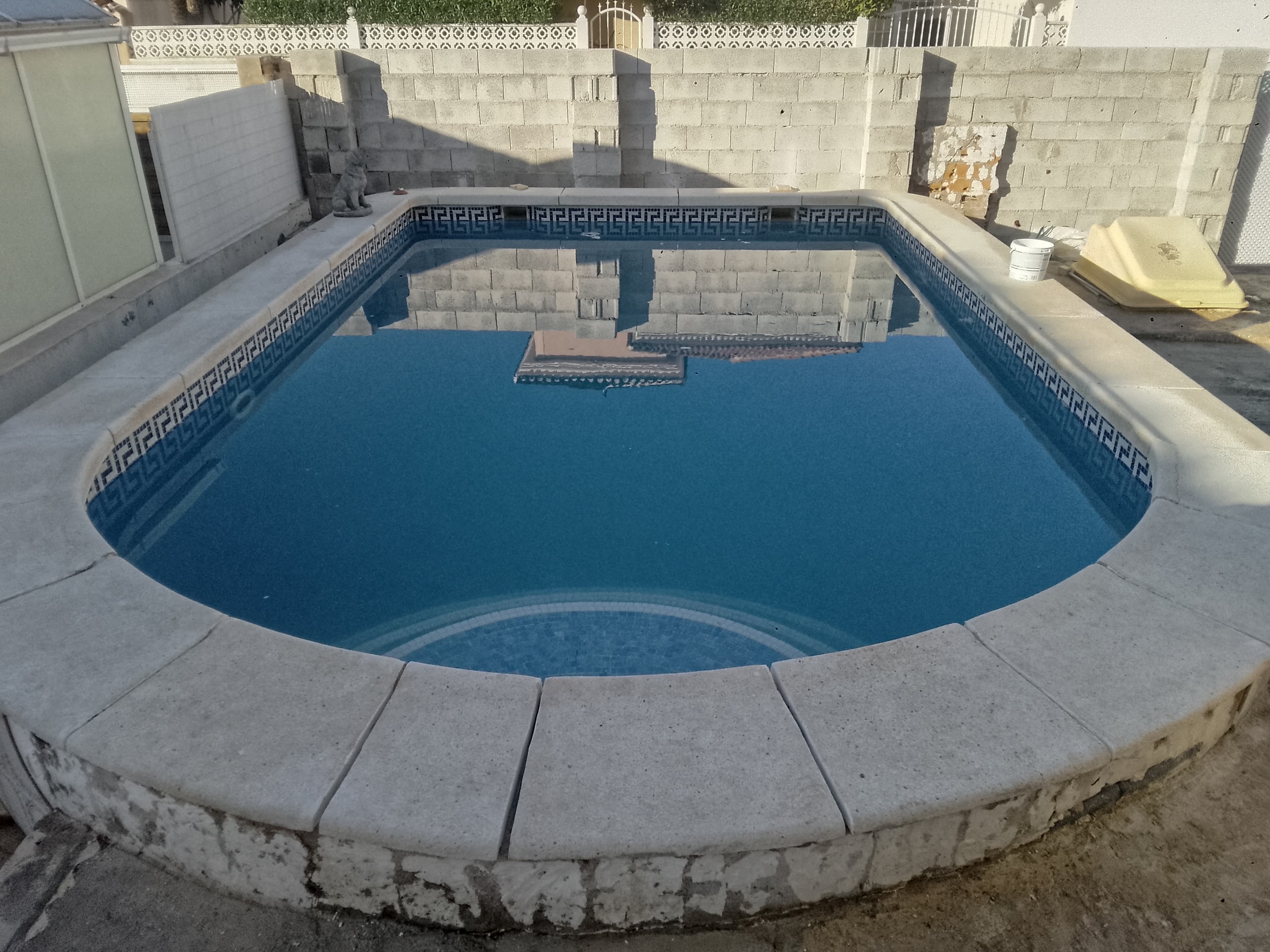 Bordillo de piscina en hormigón visto, antes de revestir en travertino
