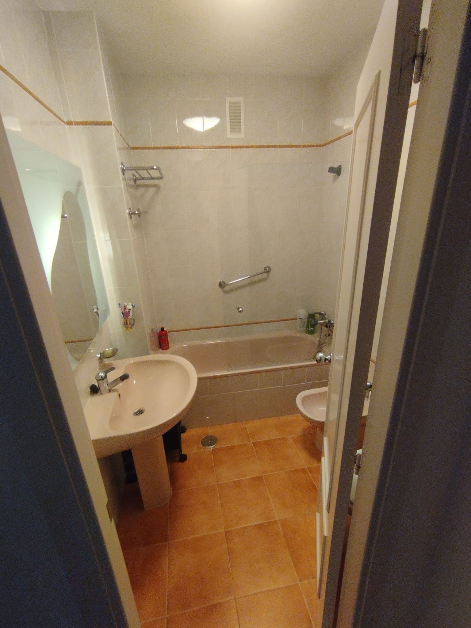 Baño antiguo con bañera, suelo de gres y azulejo con cenefa, antes de la reforma
