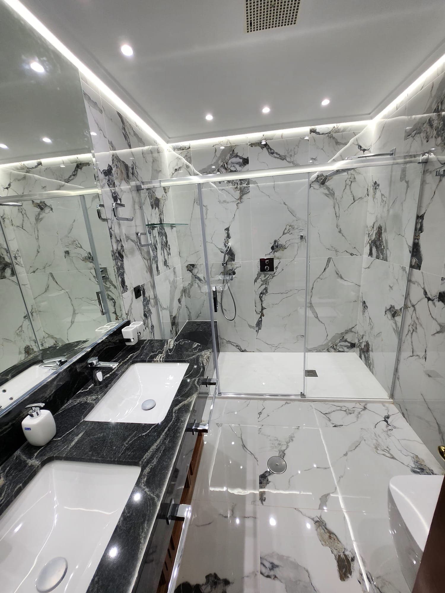 Baño terminado con mármol, doble lavabo y mueble en madera maciza