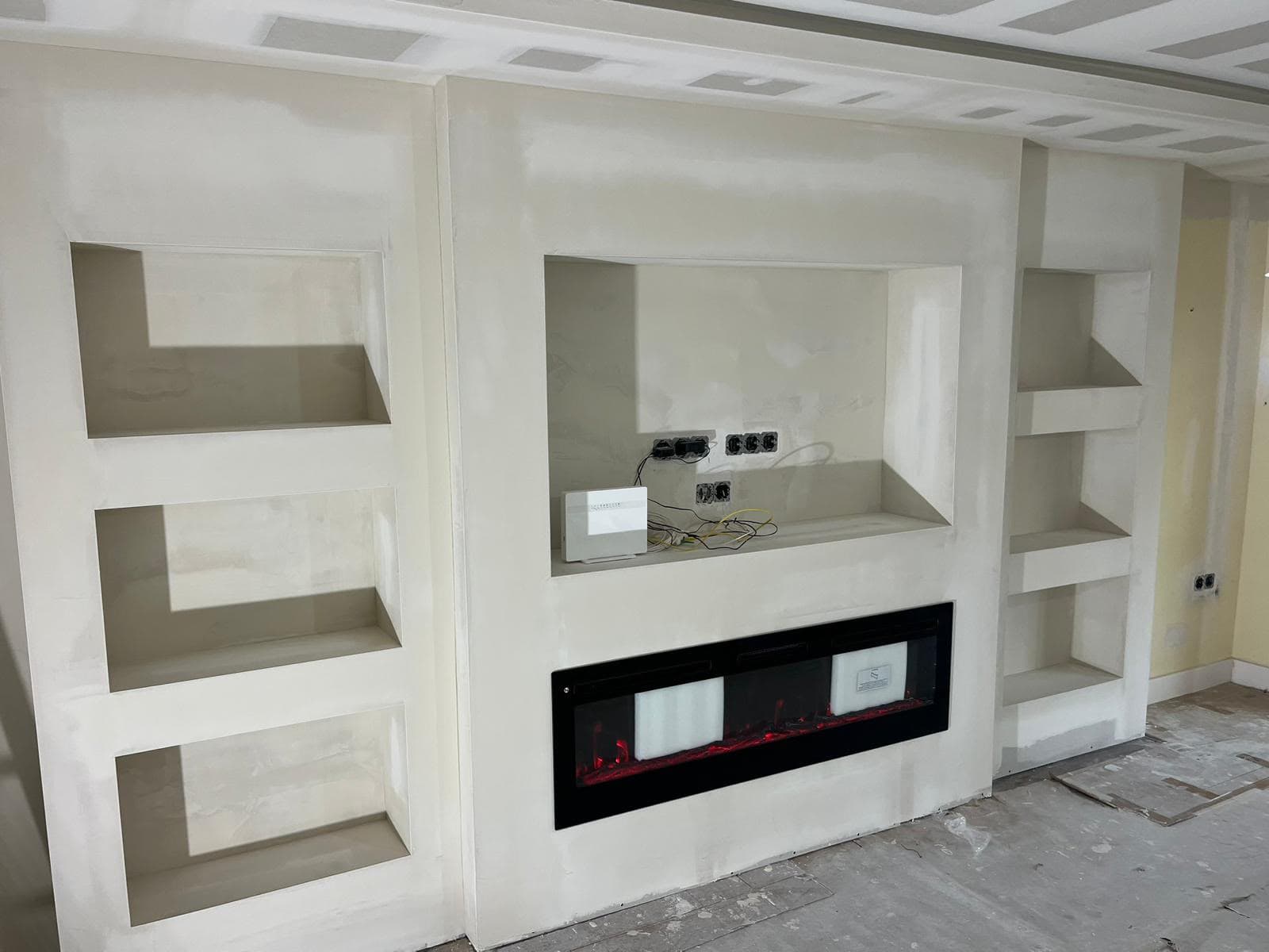 Estructura de Pladur en obra para mueble de televisión y chimenea, sin pintar