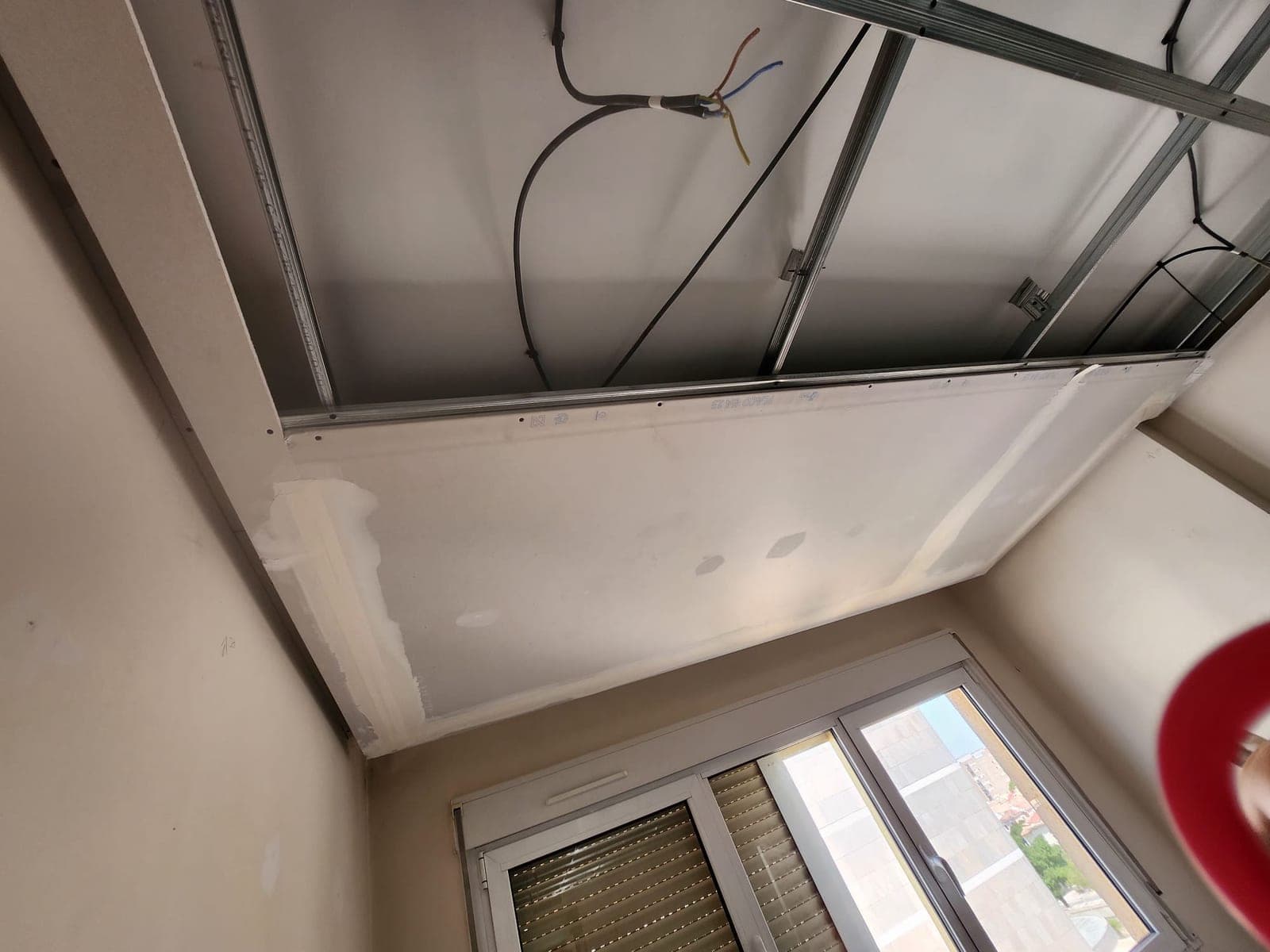 Placas de Pladur siendo colocadas sobre la estructura metálica del techo, con el cableado todavía suelto