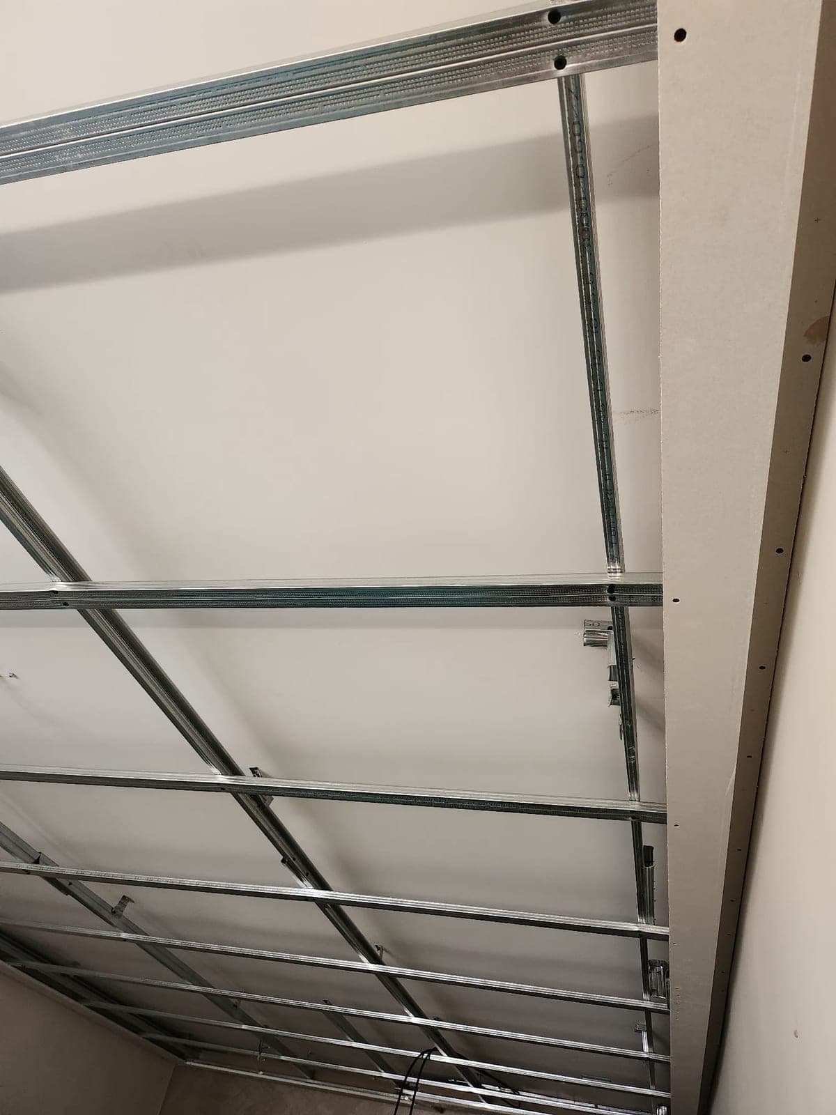 Detalle de los perfiles metálicos de la estructura del falso techo, ya anclados y escuadrados en una esquina