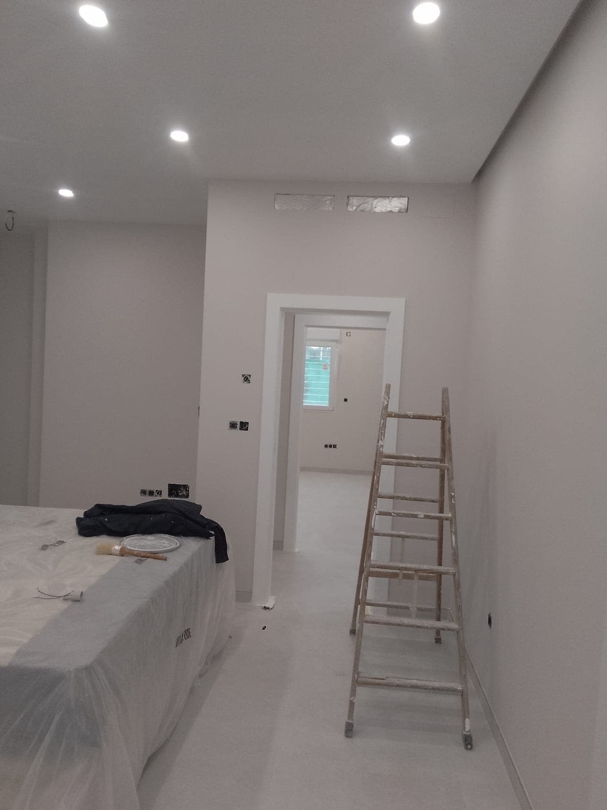 Habitación con el techo terminado y dos rejillas de salida de aire acondicionado integradas y pintadas del mismo color
