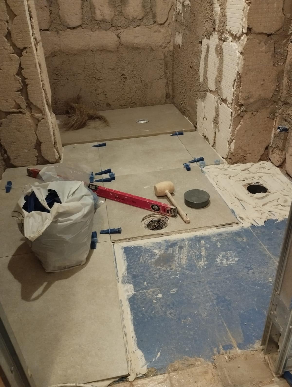 Colocación del suelo del baño con cuñas niveladoras