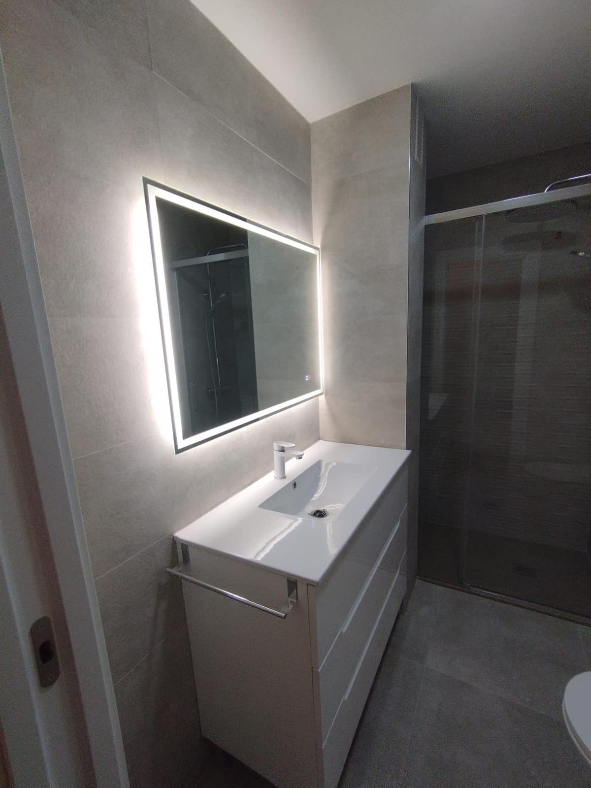 Baño terminado con ducha, mampara y mueble suspendido